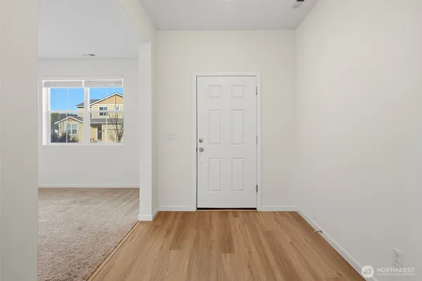 a view of a hallway with wooden floor and closet