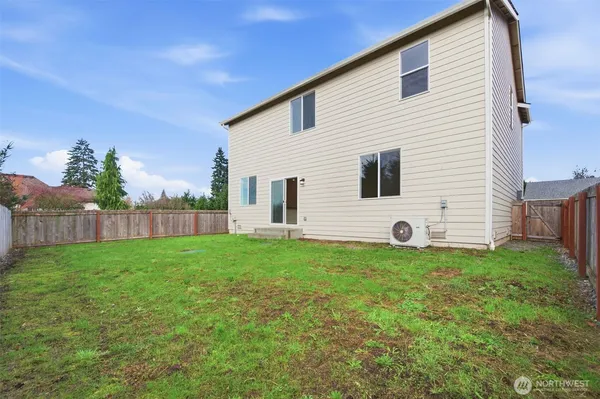 a view of a backyard with plants and wooden fence