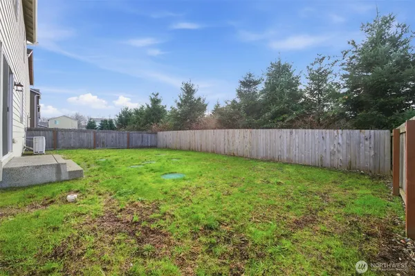 a view of yard with green space and wooden fence