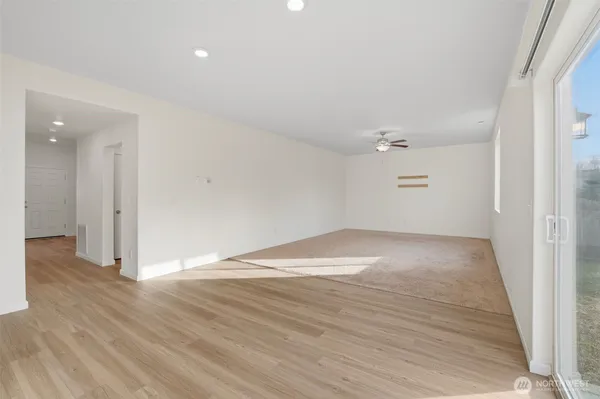 an empty room with wooden floor and white walls