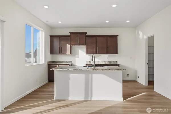 a kitchen with stainless steel appliances granite countertop a stove a sink and a microwave