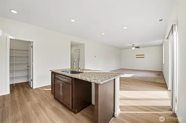 a kitchen with granite countertop a stove and a wooden floor