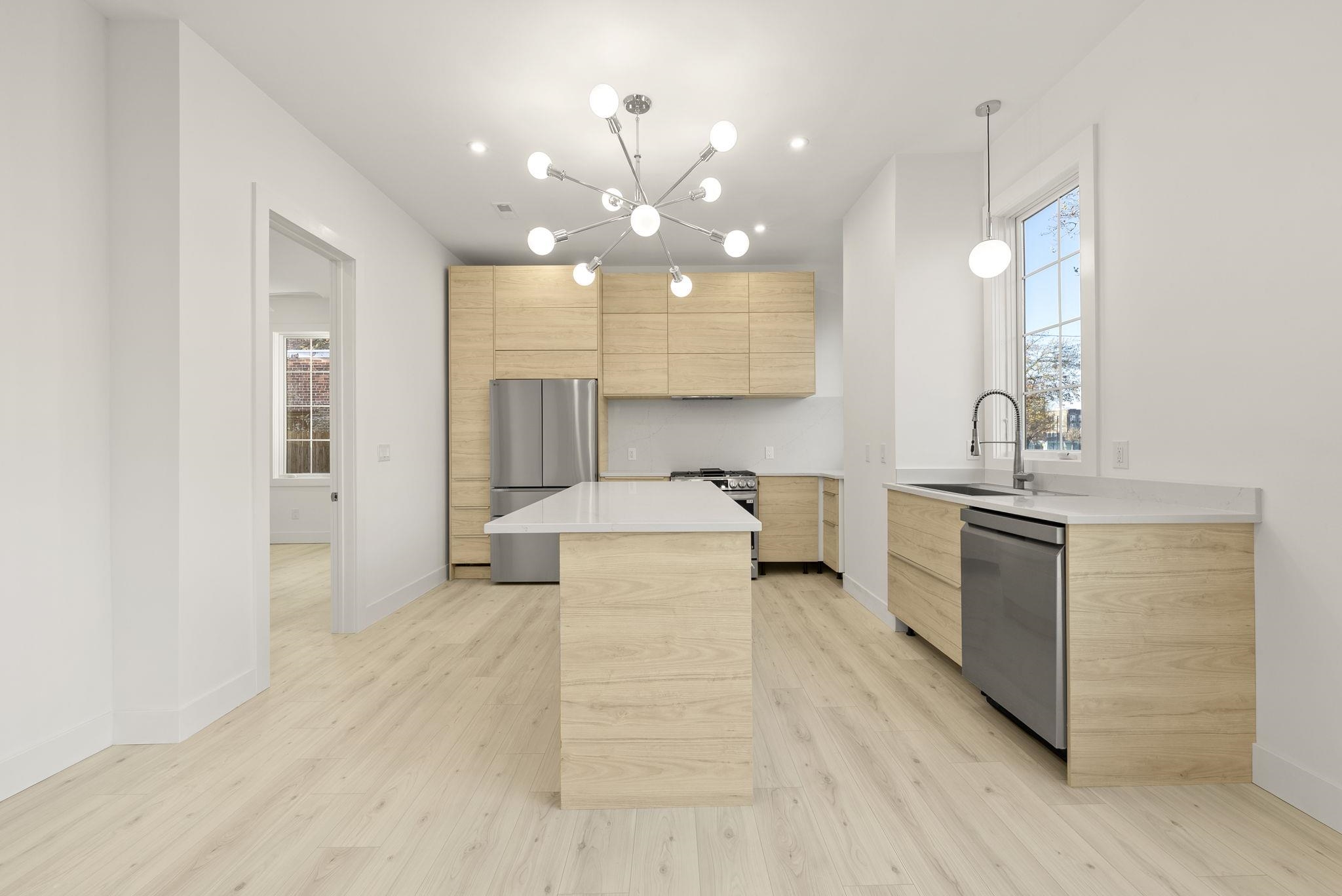 317 Sherman Avenue, Unit 1 Jersey City, NJ 07307 - Photo 11 of 29 a large white kitchen with a large island oven a stove with wooden floors