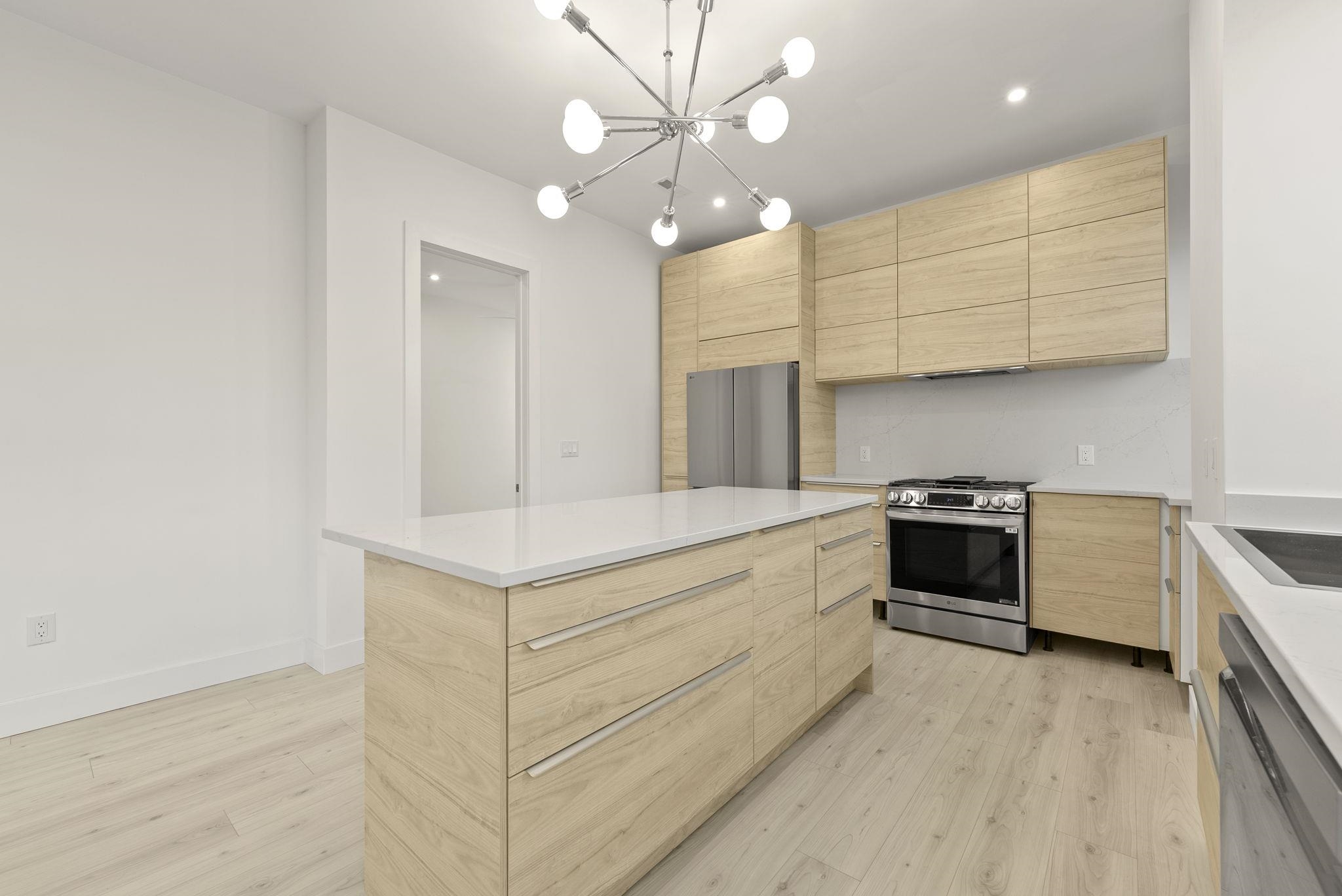 317 Sherman Avenue, Unit 1 Jersey City, NJ 07307 - Photo 12 of 29 a kitchen with stainless steel appliances a stove a sink and a refrigerator