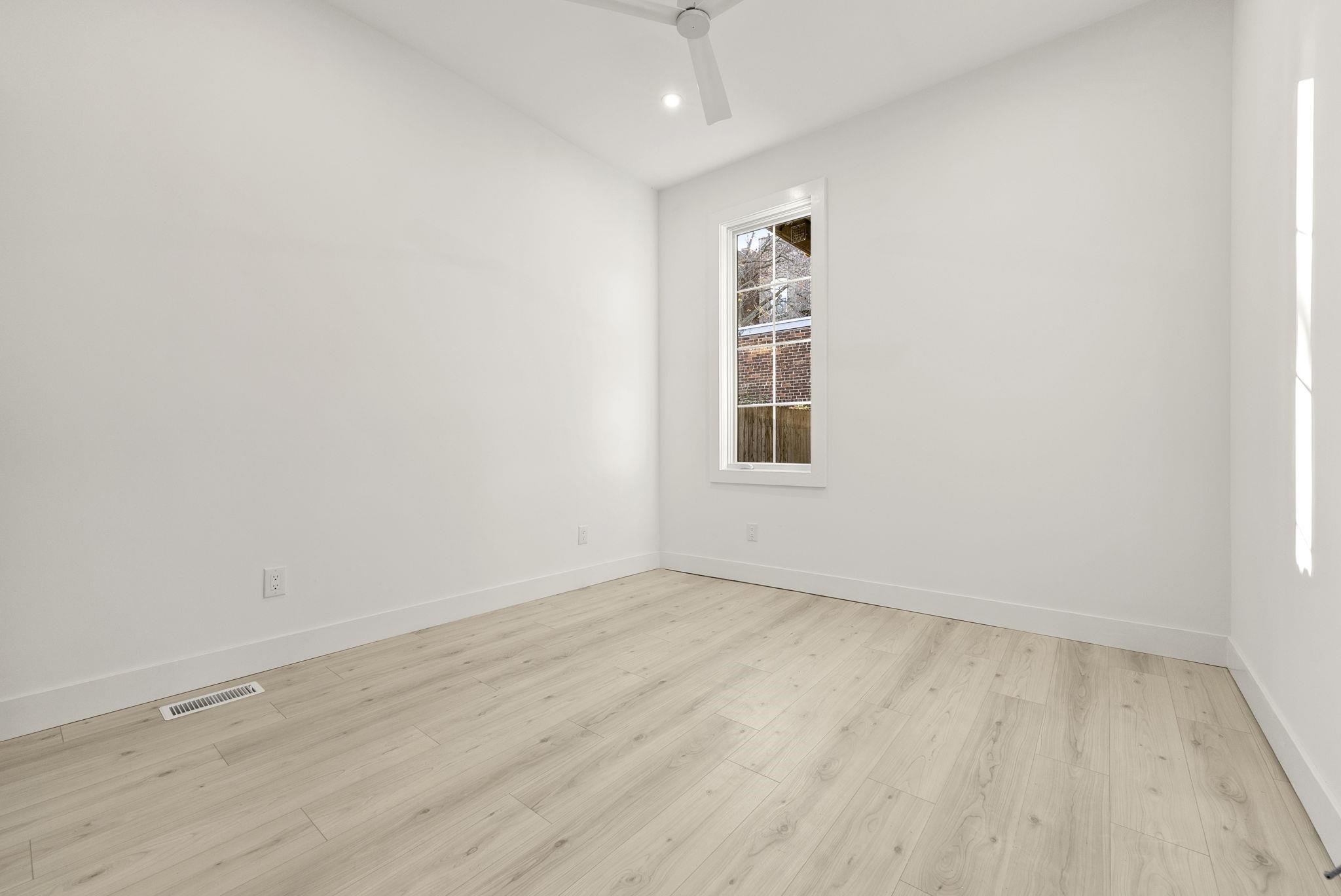 317 Sherman Avenue, Unit 1 Jersey City, NJ 07307 - Photo 21 of 29 an empty room with wooden floor and windows