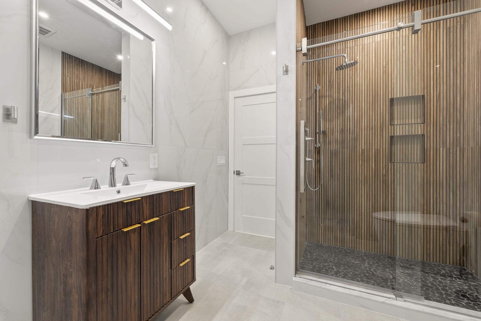 317 Sherman Avenue, Unit 1 Jersey City, NJ 07307 - Photo 22 of 29 a bathroom with a shower sink and mirror