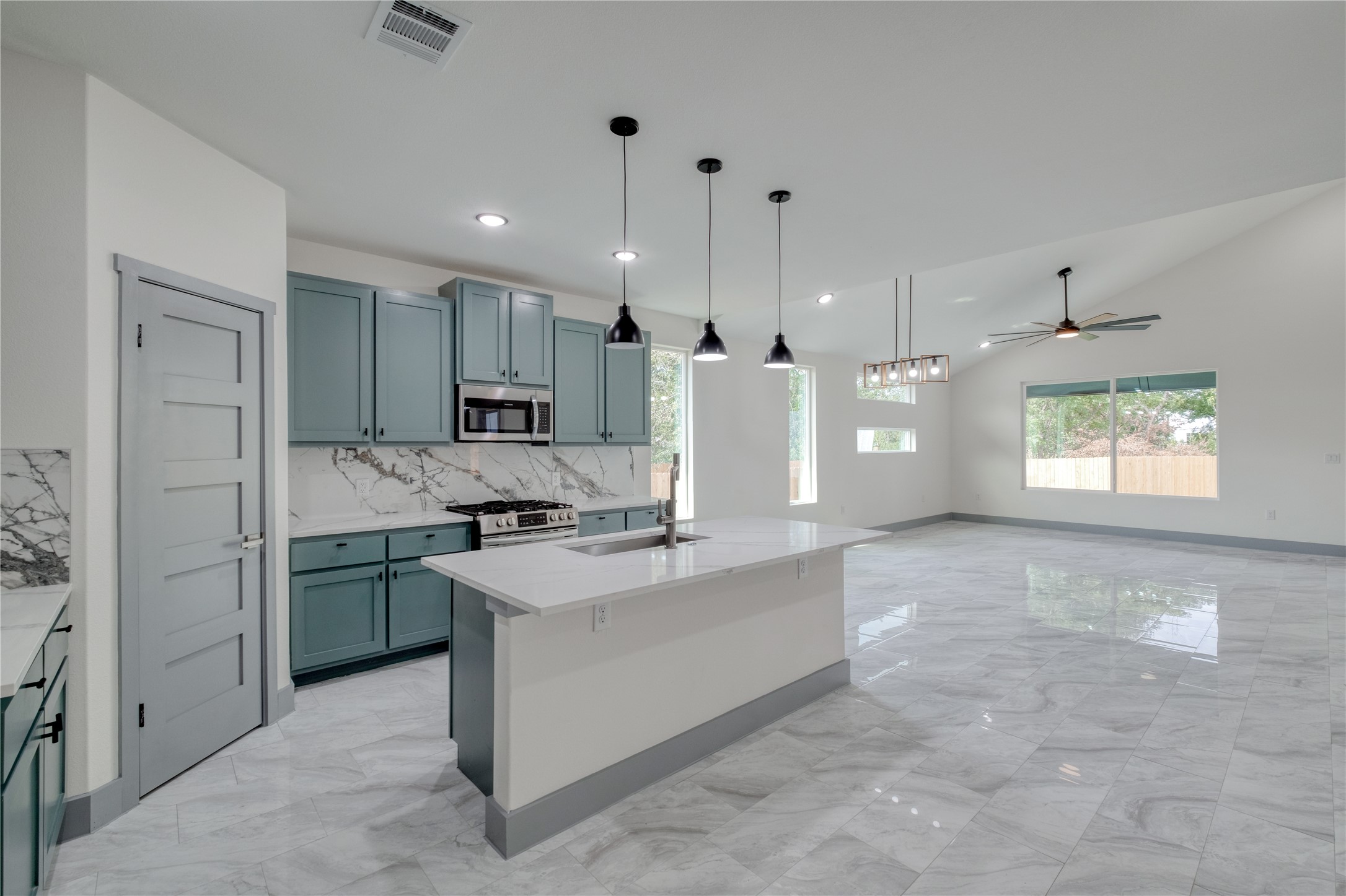 204 Washington Street Elgin, TX 78621 - Photo 4 of 24 a large kitchen with stainless steel appliances kitchen island granite countertop a refrigerator a sink a stove and white cabinets with wooden floor