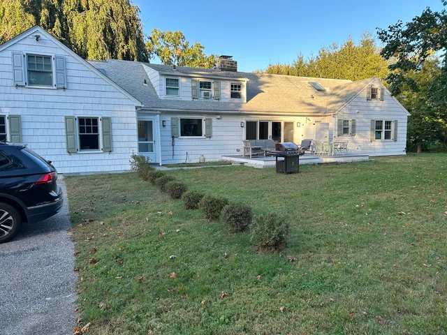a front view of a house with a garden and trees