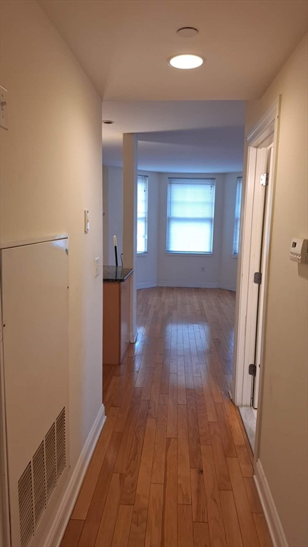 4048 Washington Street, Unit 5 Boston, MA 02131 - Photo 6 of 9 wooden floor in an empty room with a window