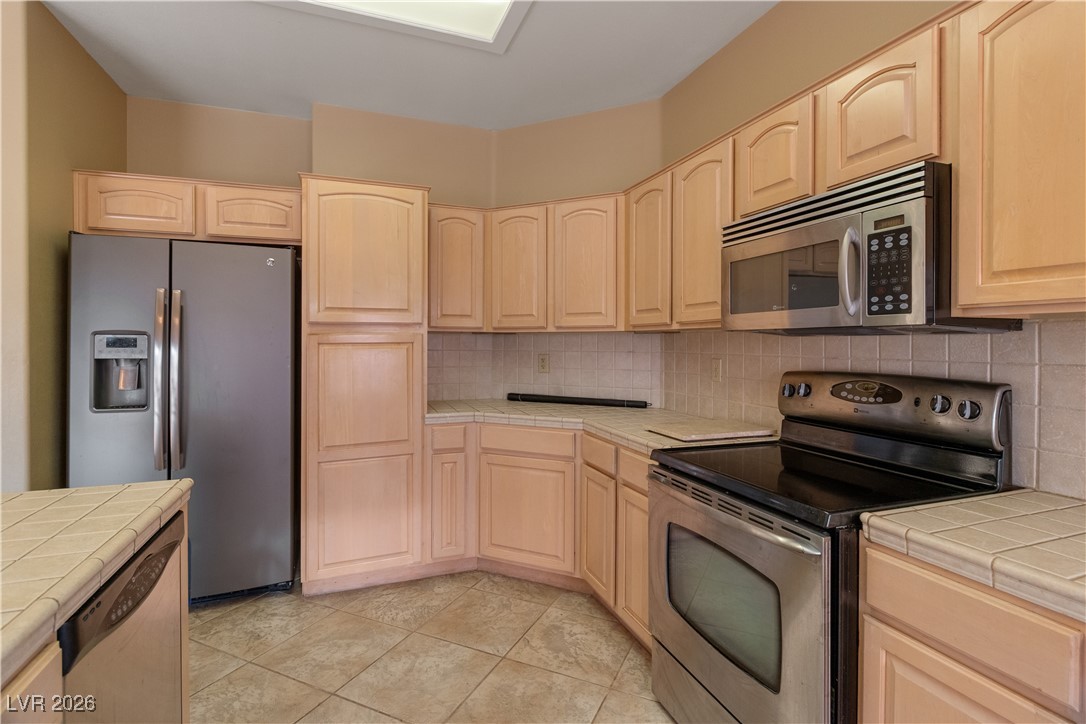 1210 Country Club Drive Laughlin, NV 89029 - Photo 11 of 80 Kitchen with tile counters, appliances with stainless steel finishes, and light brown cabinetry