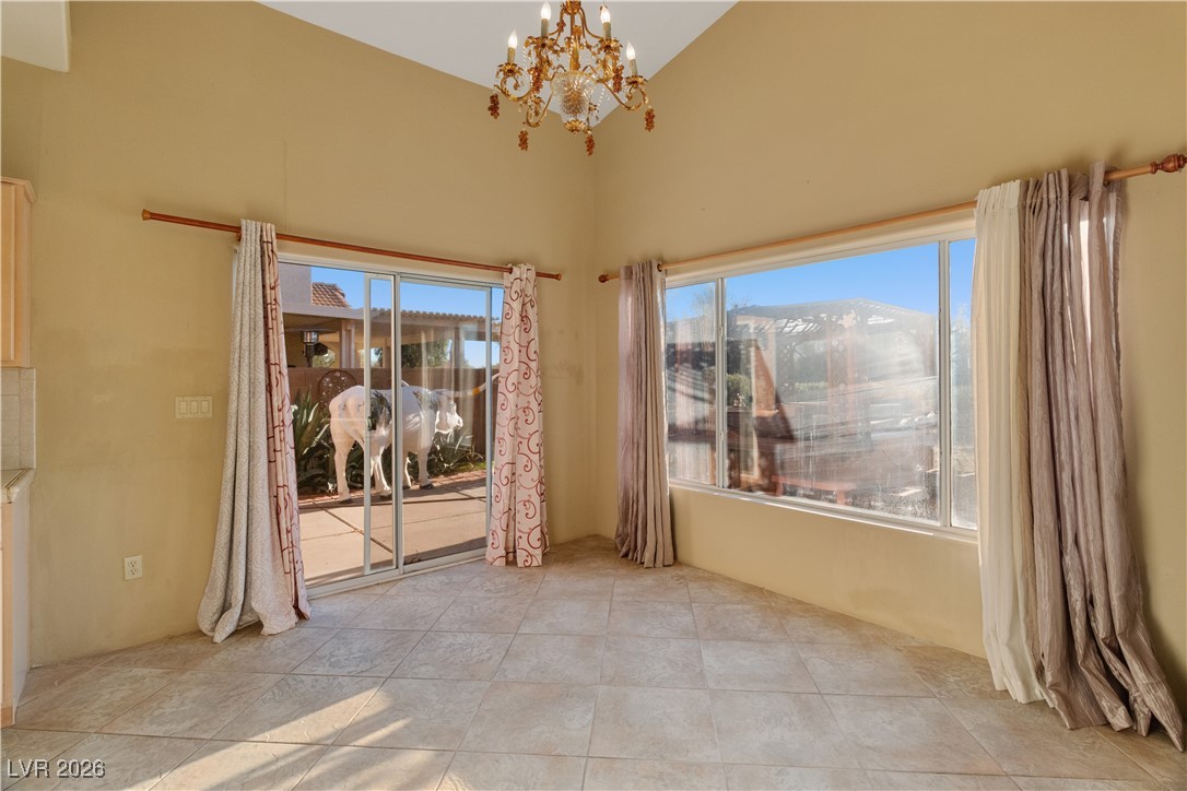 1210 Country Club Drive Laughlin, NV 89029 - Photo 16 of 80 Dining area with a chandelier, high vaulted ceiling, and light tile patterned floors