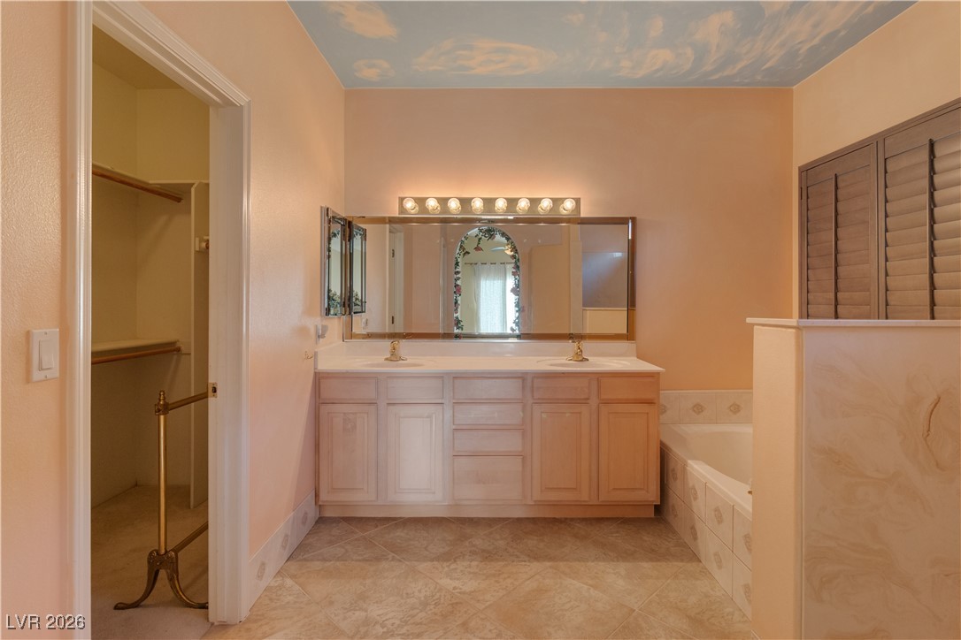 1210 Country Club Drive Laughlin, NV 89029 - Photo 21 of 80 Primary Ensuite Bathroom featuring double vanity, a bath, and a walk in closet