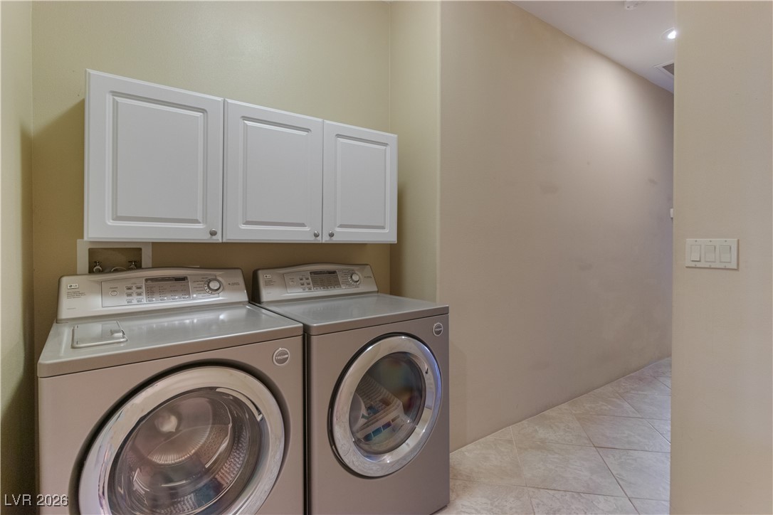 1210 Country Club Drive Laughlin, NV 89029 - Photo 37 of 80 Laundry area in hallway featuring independent washer and dryer, cabinet space, and light tile patterned floors
