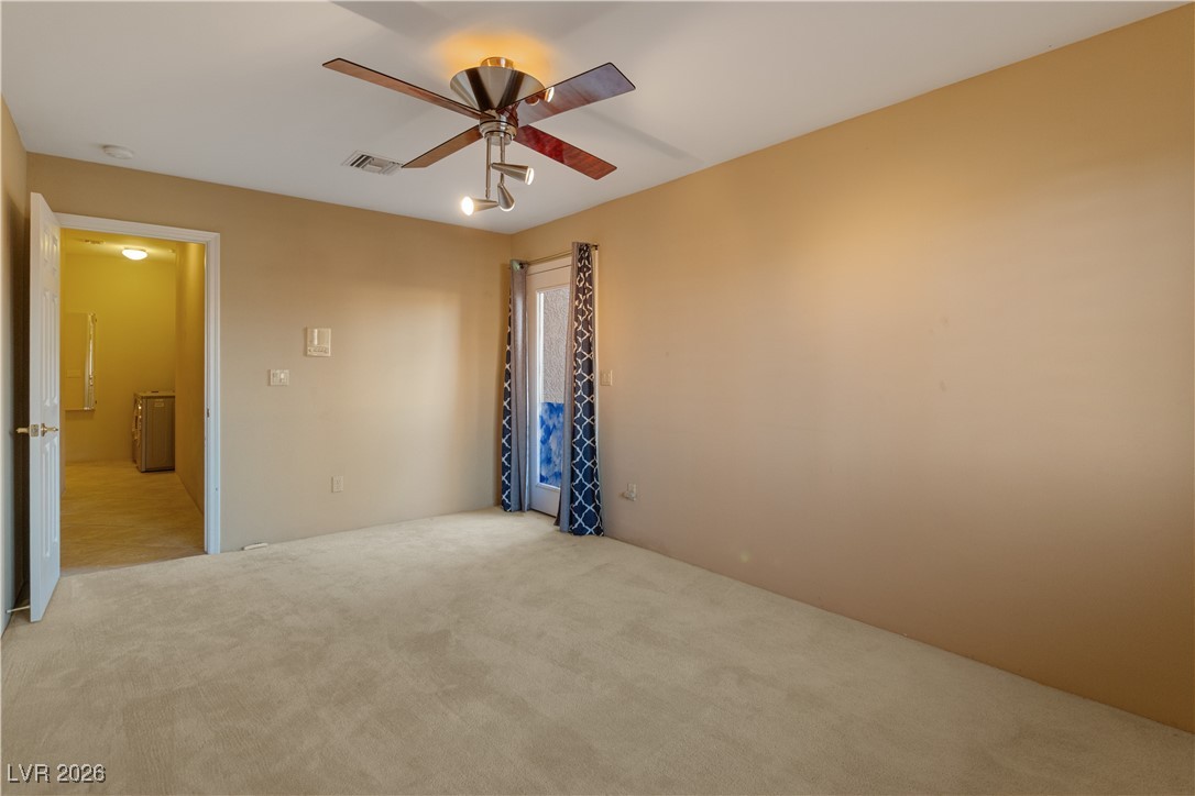 1210 Country Club Drive Laughlin, NV 89029 - Photo 40 of 80 Third bedroom featuring a ceiling fan, carpet, and door access to the front exterior of the home, perfect for guest entry or a home office
