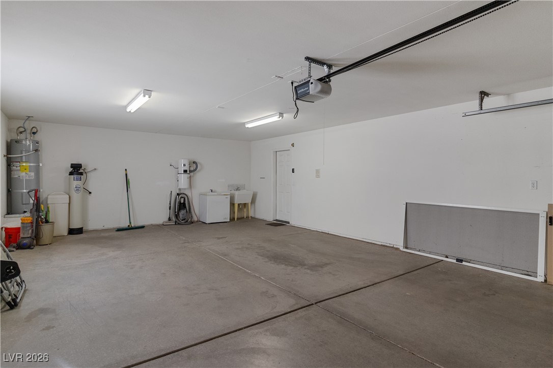 1210 Country Club Drive Laughlin, NV 89029 - Photo 46 of 80 Garage featuring strapped water heater, water softener, and an automatic garage door opener