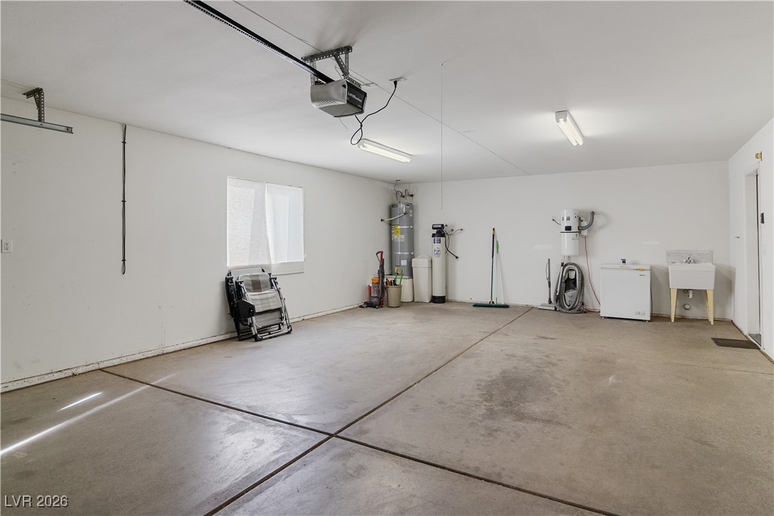 1210 Country Club Drive Laughlin, NV 89029 - Photo 47 of 80 Garage featuring strapped water heater, water softener, and an automatic garage door opener