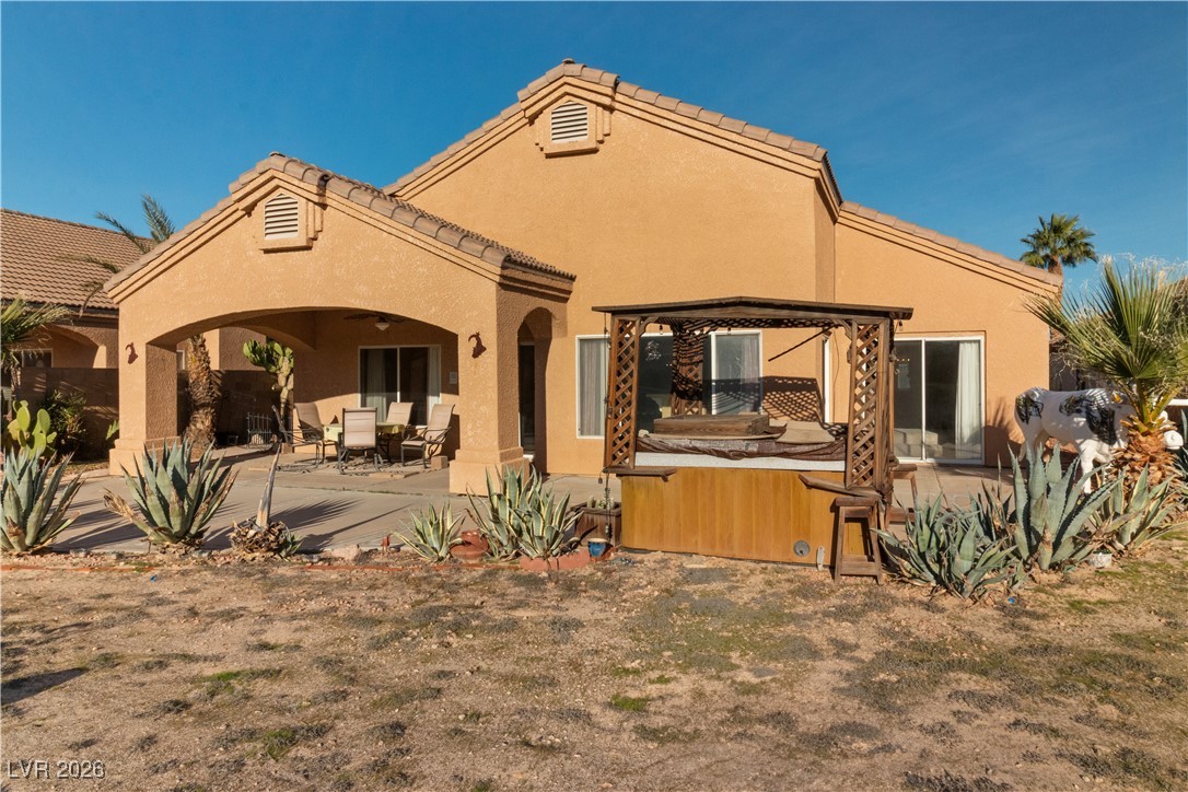 1210 Country Club Drive Laughlin, NV 89029 - Photo 57 of 80 Rear view of property featuring a patio area, stucco siding, and a hot tub