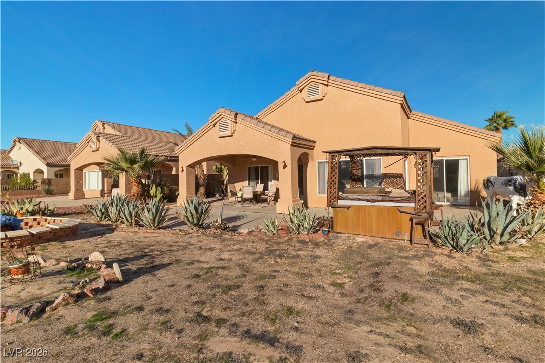 1210 Country Club Drive Laughlin, NV 89029 - Photo 58 of 80 Rear view of property with stucco siding, a patio area, and a hot tub