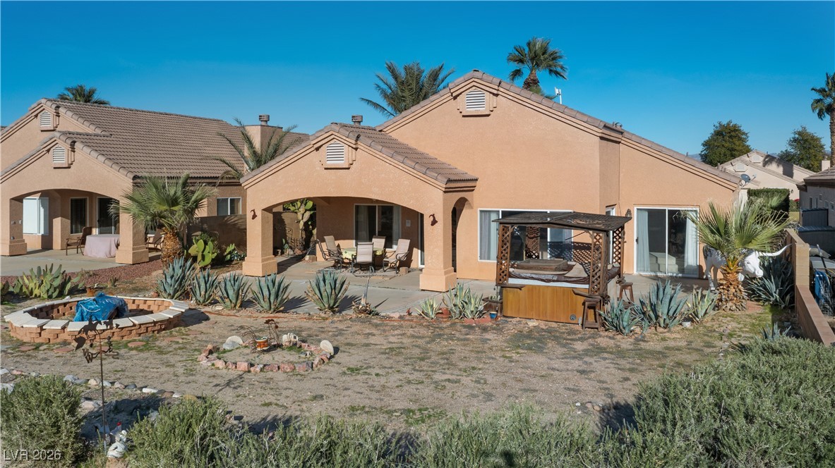 1210 Country Club Drive Laughlin, NV 89029 - Photo 64 of 80 Back of house featuring a hot tub, stucco siding, and a patio area