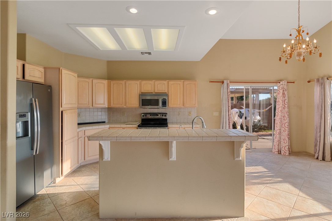 1210 Country Club Drive Laughlin, NV 89029 - Photo 8 of 80 Kitchen with tile countertops, light brown cabinetry, appliances with stainless steel finishes, a breakfast bar, and recessed lighting