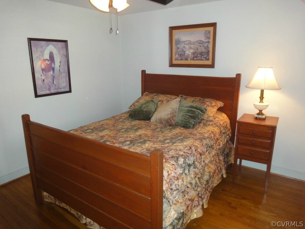 2716 East Brigstock Road Midlothian, VA 23113 - Photo 14 of 24 a bedroom with a bed and a lamp on table with wooden floor