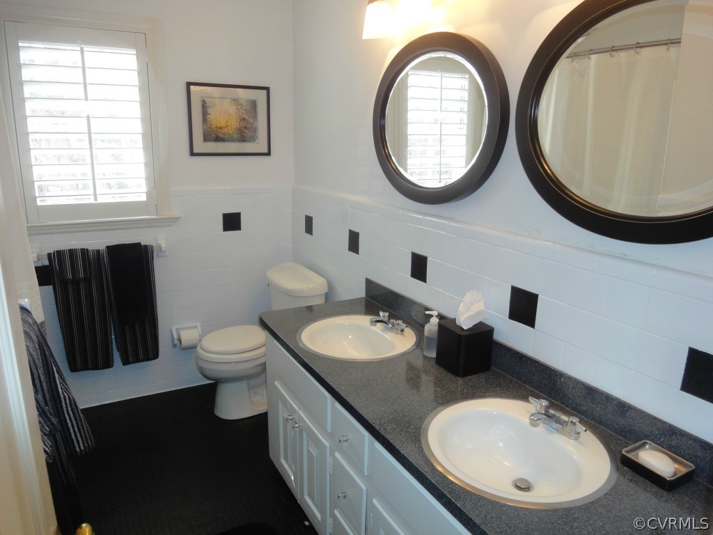 2716 East Brigstock Road Midlothian, VA 23113 - Photo 16 of 24 a bathroom with a toilet a sink and a mirror