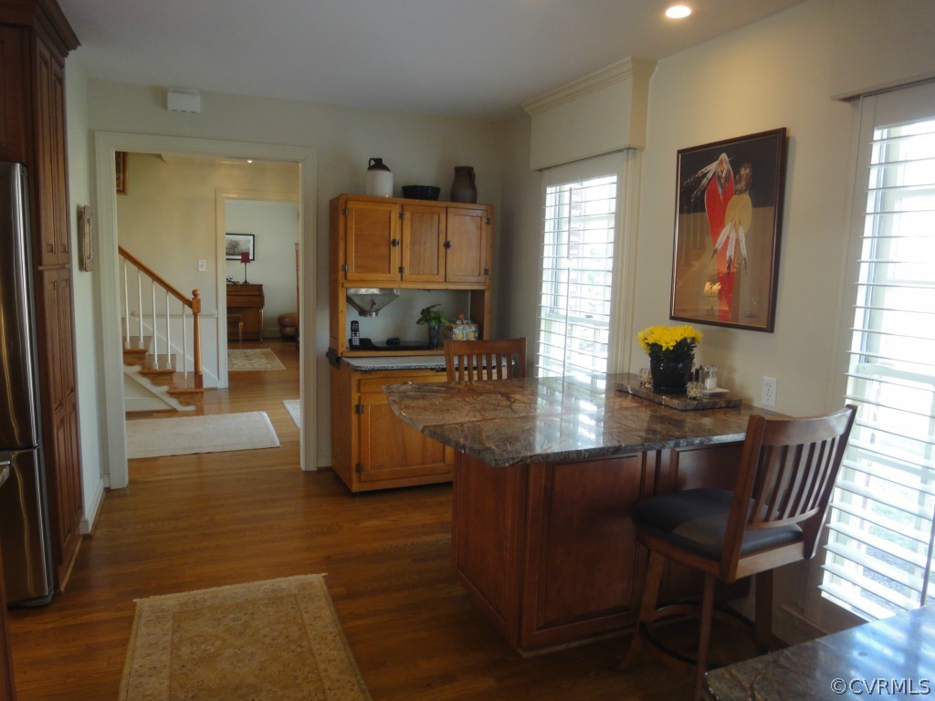 2716 East Brigstock Road Midlothian, VA 23113 - Photo 7 of 24 a kitchen with stainless steel appliances granite countertop a refrigerator a stove a sink a dining table and chairs with wooden floor