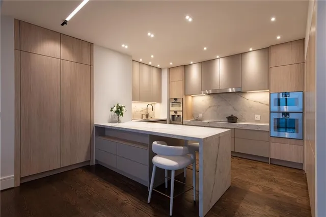 a living room with furniture a flat screen tv and a wooden floor