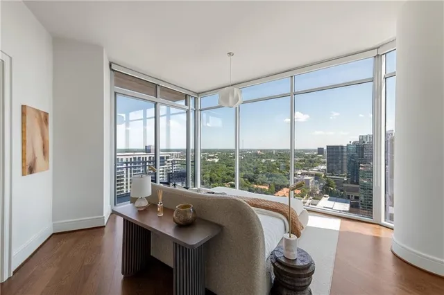 a living room with furniture a wooden floor and a large window