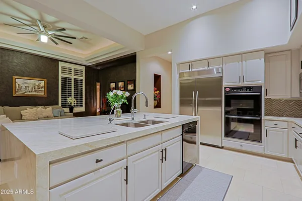 a view of a dining room with furniture large windows and a chandelier