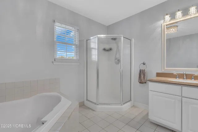 a bathroom with a bathtub a sink a vanity and a shower