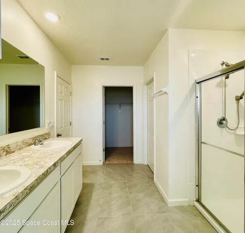 a bathroom with a granite countertop sink mirror and shower