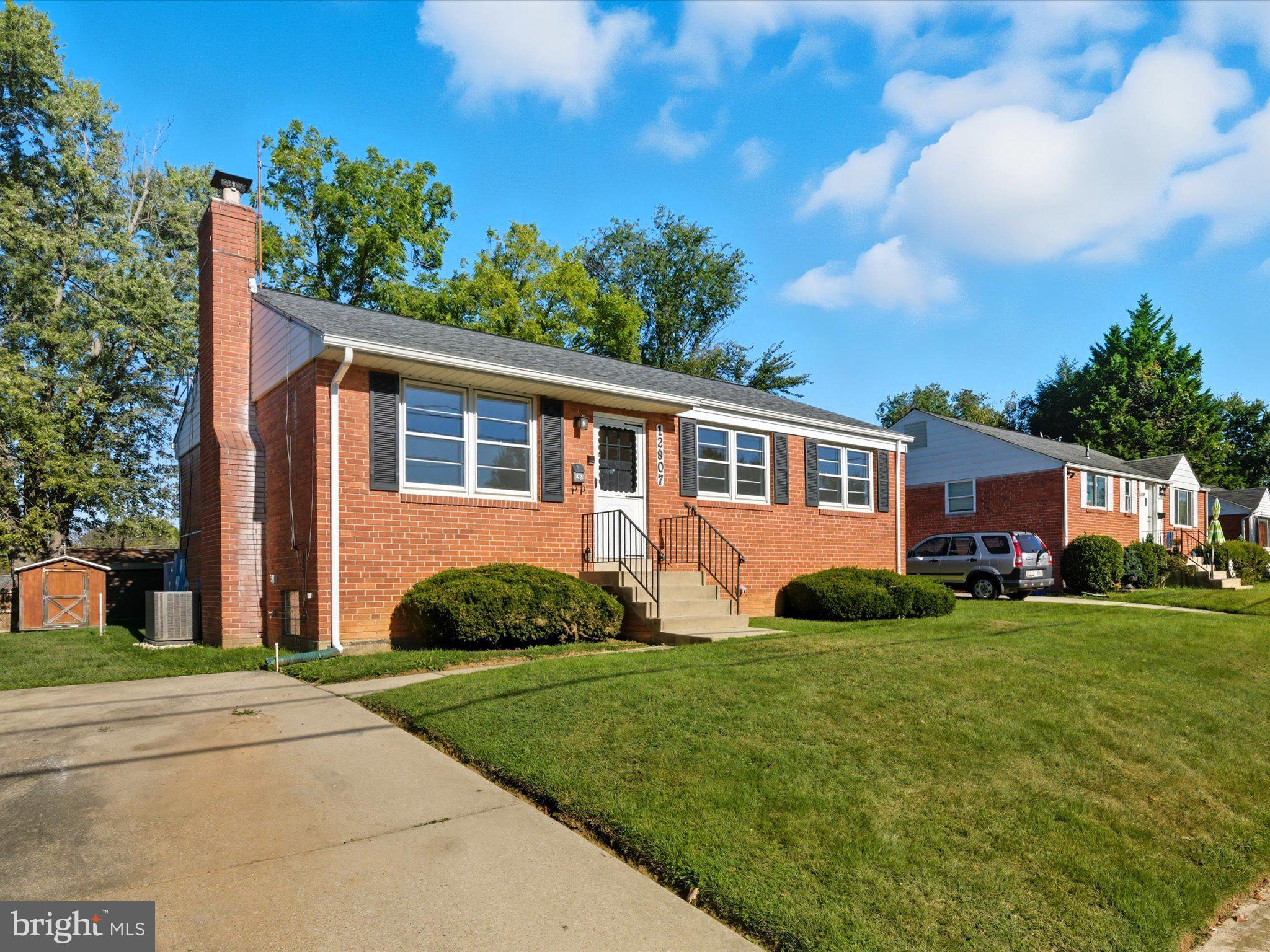 12907 Matey Road Silver Spring, MD 20906 - Photo 3 of 45 a front view of a house with a yard and trees