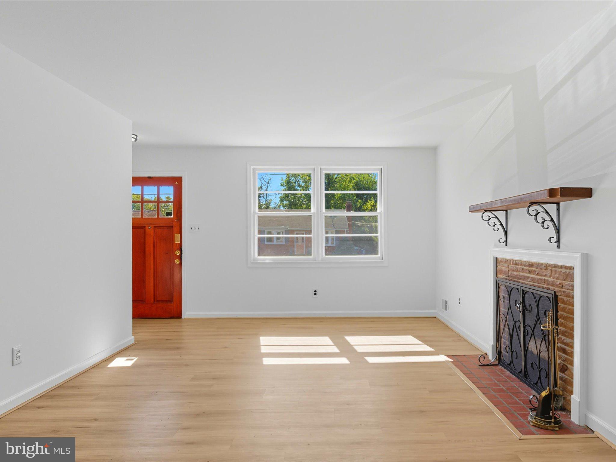 12907 Matey Road Silver Spring, MD 20906 - Photo 7 of 45 an empty room with windows fireplace and wooden floor