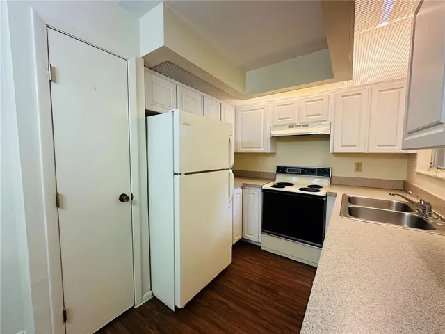 a kitchen with a refrigerator and a sink