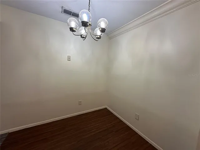 a view of a room with wooden floor and chandelier