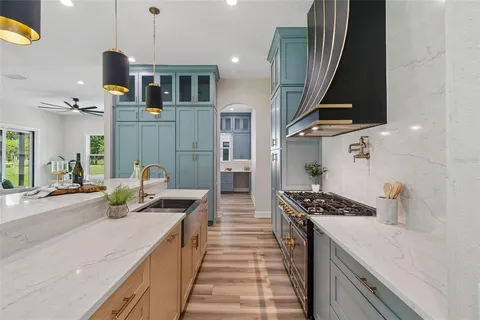 a view of a kitchen with wooden floor and electronic appliances
