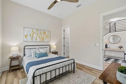 a living room with furniture large windows and wooden floor