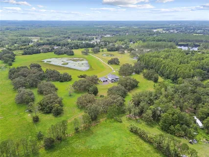 a dining room with wooden floor a chandelier a glass table and chairs