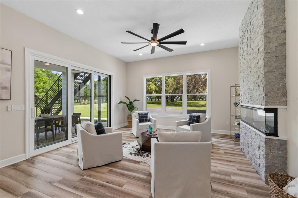 13711 Lussier Lane Spring Hill, FL 34610 - Photo 41 of 88 a living room with furniture large windows and wooden floor