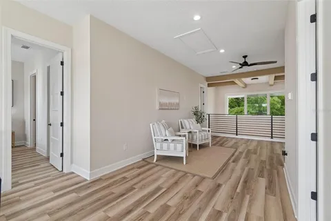a view of a white house with a big yard and large trees
