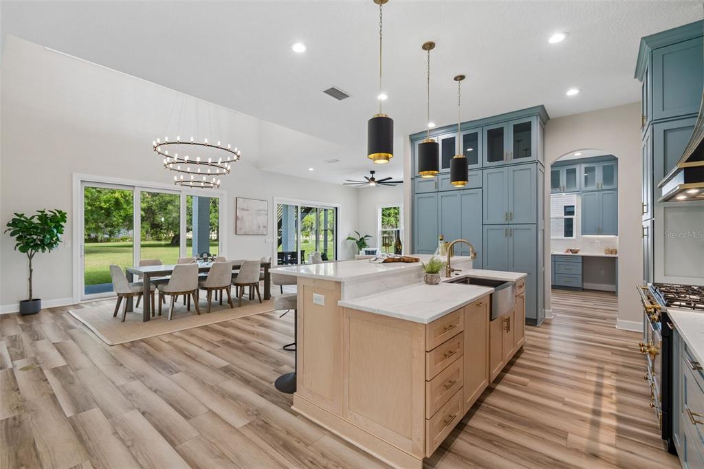 13711 Lussier Lane Spring Hill, FL 34610 - Photo 5 of 88 a large kitchen with stainless steel appliances granite countertop a lot of cabinets and wooden floors