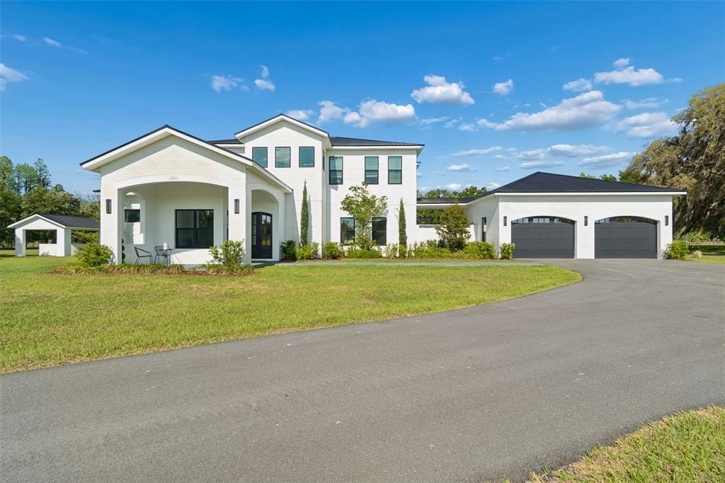 13711 Lussier Lane Spring Hill, FL 34610 - Photo 86 of 88 a view of a white house with a big yard and large trees