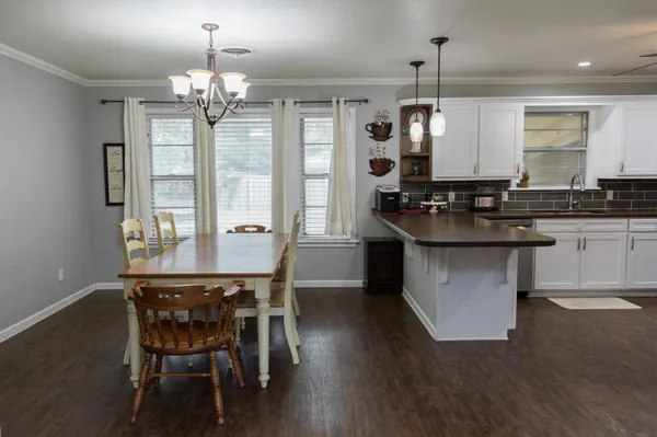 a kitchen with stainless steel appliances granite countertop a dining table chairs and granite counter tops