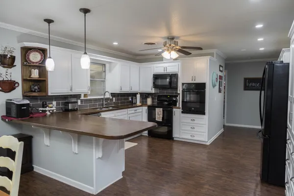 a kitchen with stainless steel appliances granite countertop a sink a stove and a refrigerator
