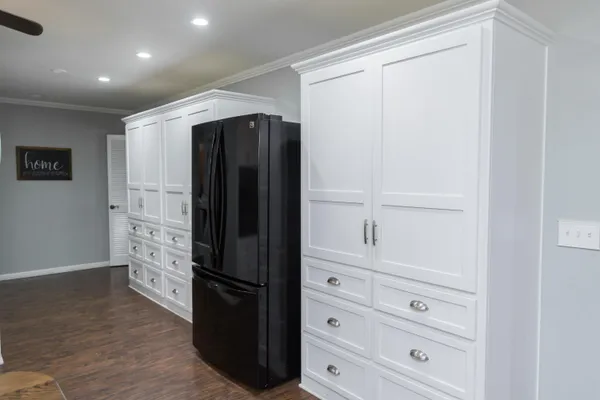a kitchen with white cabinets and refrigerator