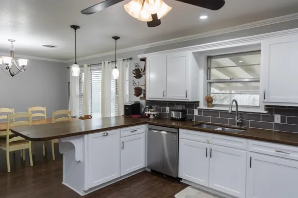 a kitchen with appliances cabinets and chair