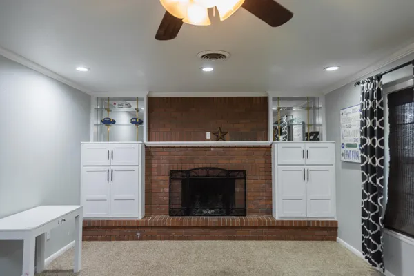 a view of empty room with windows and ceiling fan