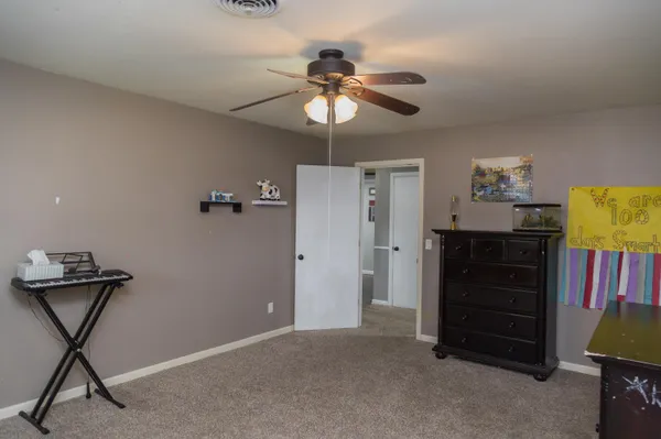 a living room with furniture and a ceiling fan