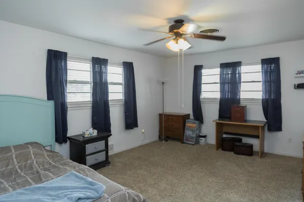 a view of a bedroom with baby crib and closet
